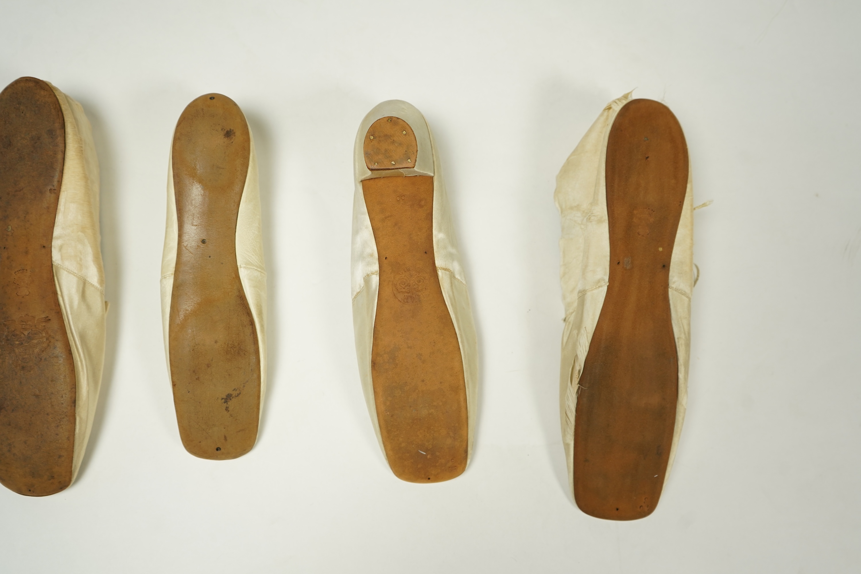 A 19th century hand made cream kid leather ladies ankle boot and four differing cream silk and satin single wedding shoes. All with leather soles. Possibly a traveller's sample range. Boots 24.5cm long (heel to toe). Con